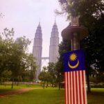 Vista de las Torres Petronas y bandera de Malasia desde el Parque KLCC