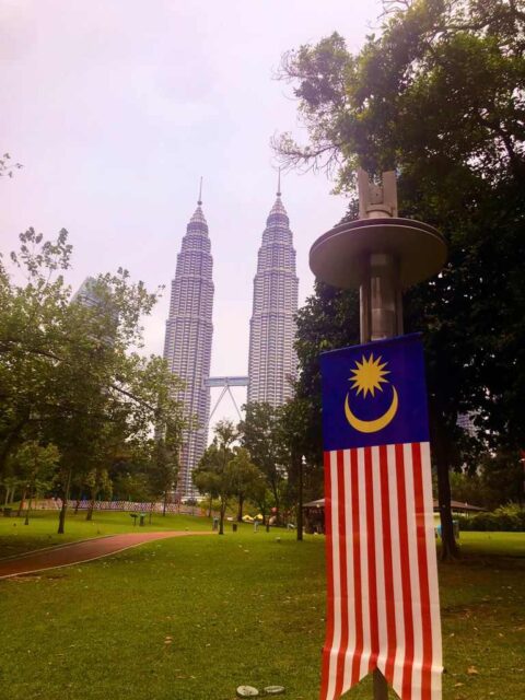 Vista de las Torres Petronas y bandera de Malasia desde el Parque KLCC