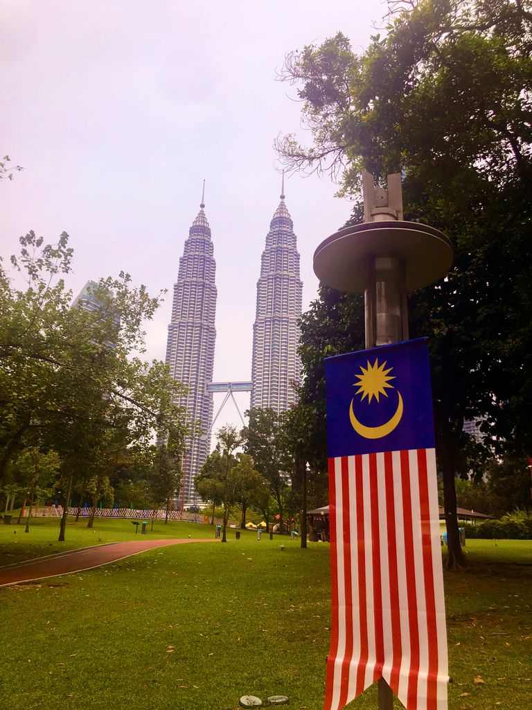 Vista de las Torres Petronas y bandera de Malasia desde el Parque KLCC